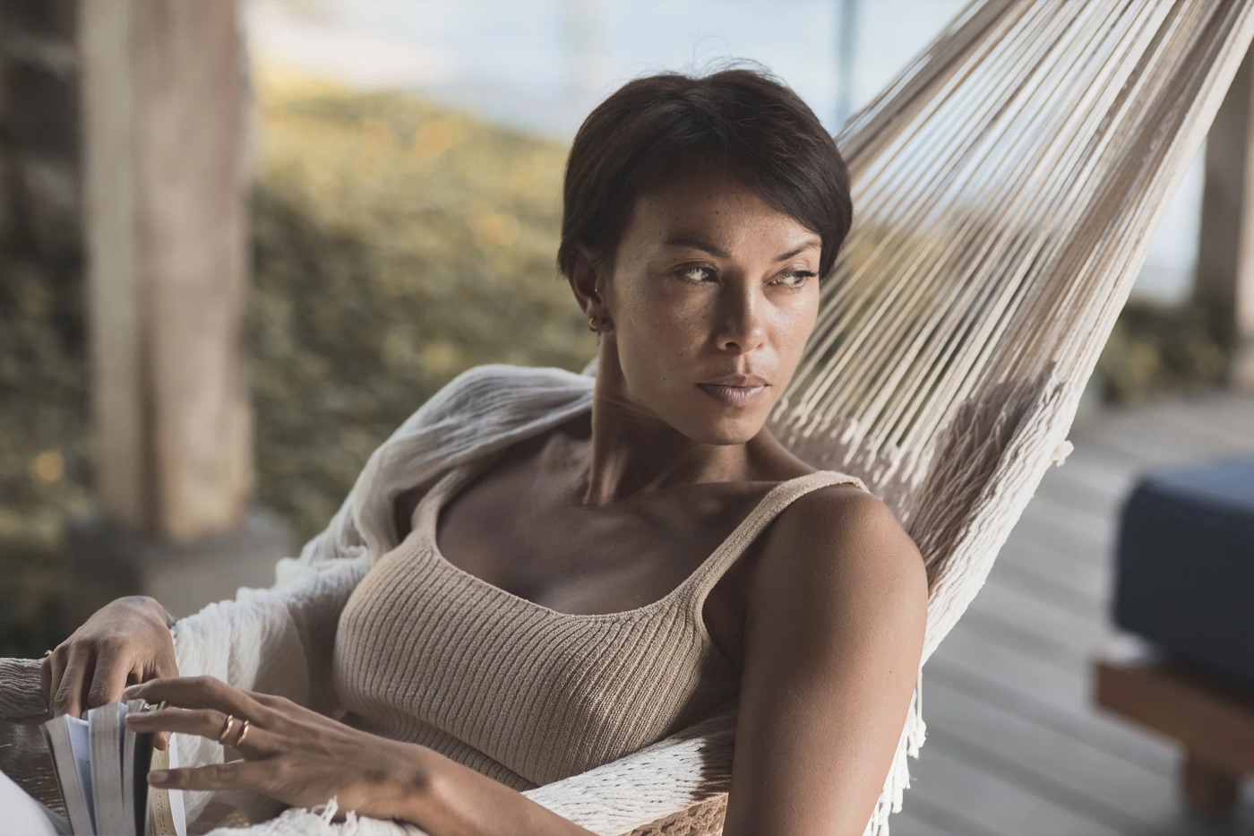 Kimberley Utama seated in a hammock lounge, relaxed and smiling.